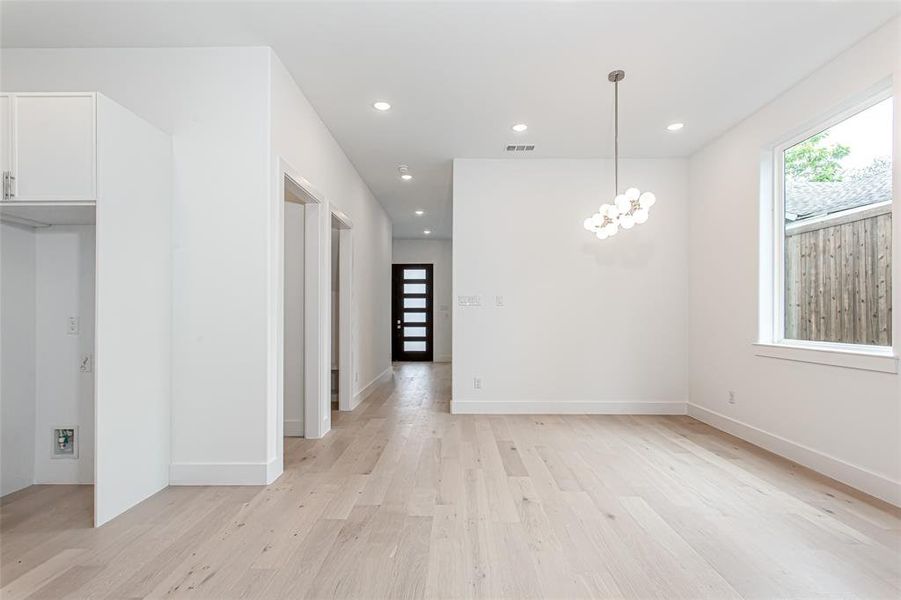 Unfurnished dining area featuring light wood-style flooring, recessed lighting, a chandelier, and baseboards