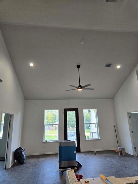 Living room with lofted ceiling and ceiling fan
