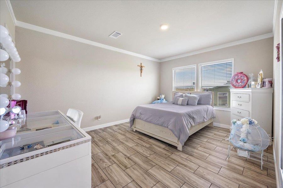 Bedroom with wood tiled floors and ornamental molding Bedroom with wood tiled floors and ornamental molding