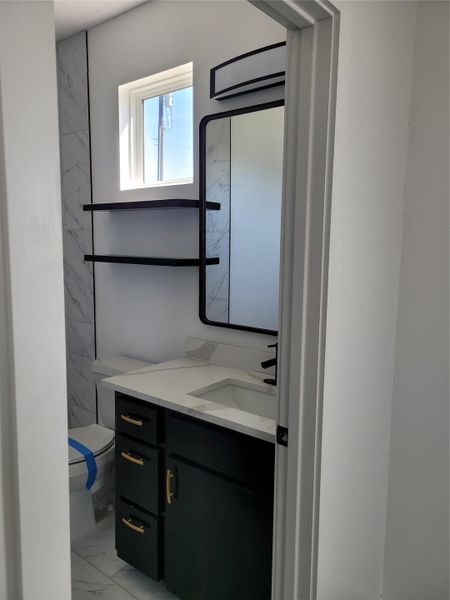 Modern bathroom featuring sleek black cabinetry, a white countertop, and stylish black fixtures with a large mirror. Modern bathroom featuring sleek black cabinetry, a white countertop, and stylish black fixtures with a large mirror.