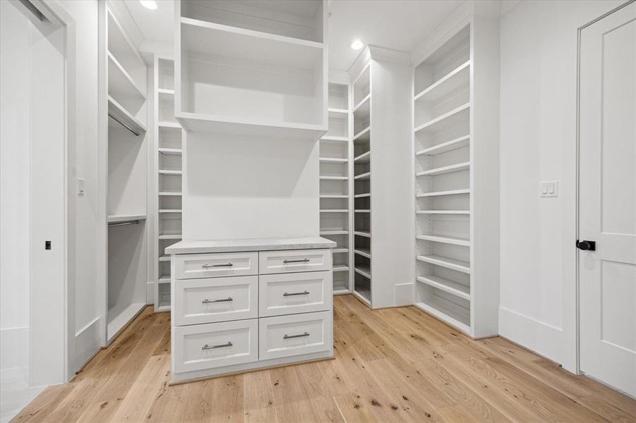 PRIMARY CLOSET: Ample space meets impeccable craftsmanship in this primary closet, where custom shelving, racks, and drawers create an organized oasis for your clothing and accessories. The clever layout allows for effortless organization, ensuring that every item has its designated place.