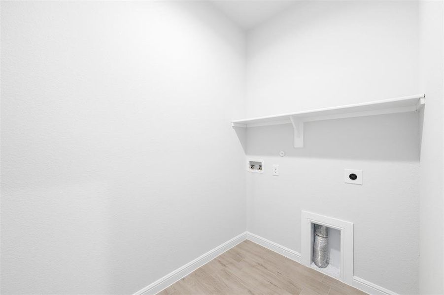 Clothes washing area featuring gas dryer hookup, washer hookup, electric dryer hookup, and light wood-type flooring