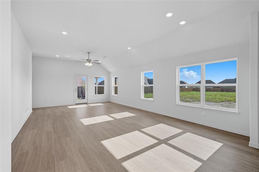 Unfurnished living room with light wood-style flooring, recessed lighting, vaulted ceiling, and ceiling fan Unfurnished living room with light wood-style flooring, recessed lighting, vaulted ceiling, and ceiling fan