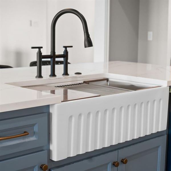 Kitchen view of gray cabinets, light stone countertops, and blue cabinetry Kitchen view of gray cabinets, light stone countertops, and blue cabinetry