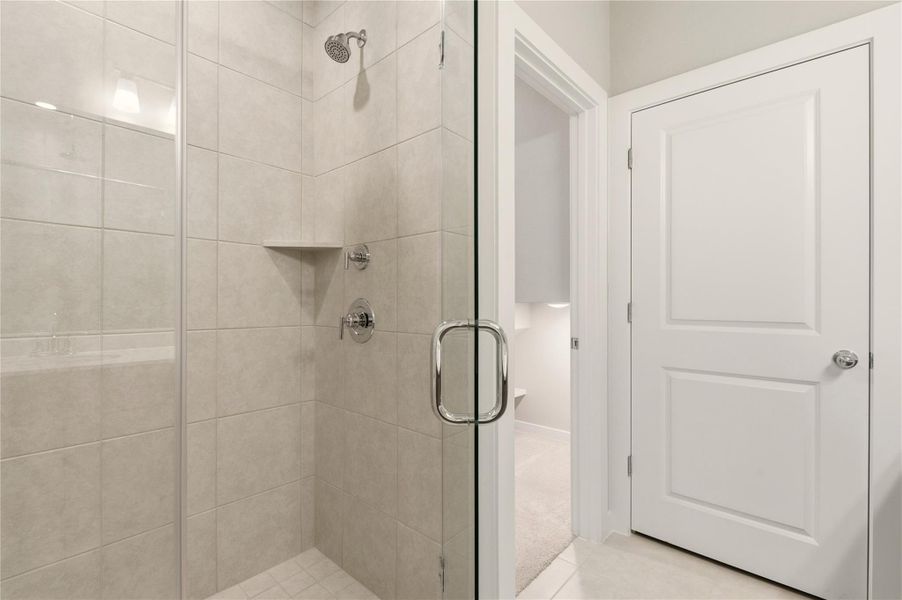 Full bath featuring a stall shower and light colored carpet