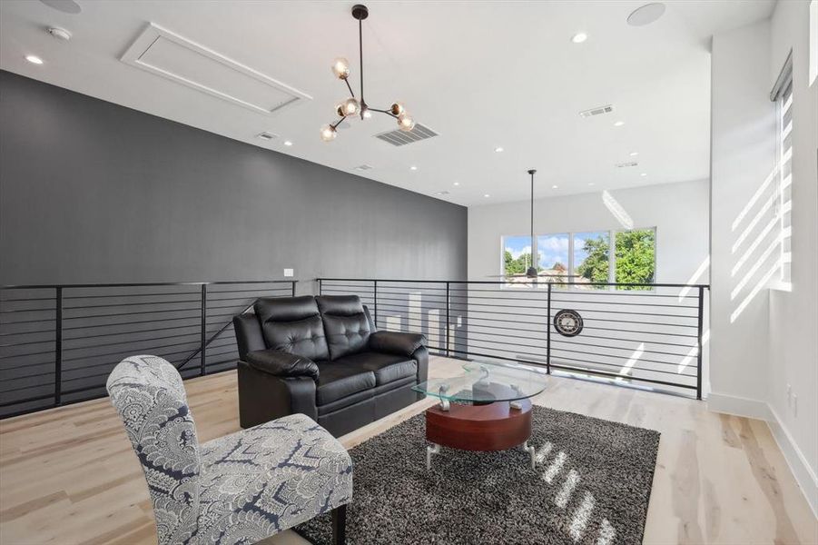 Living room with an inviting chandelier and light hardwood / wood-style flooring