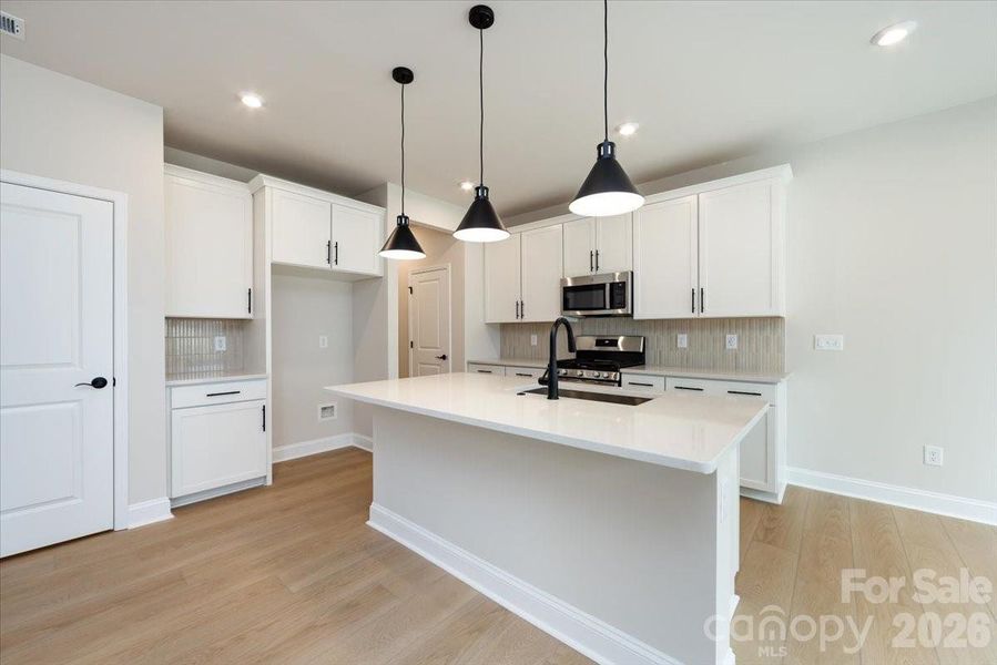 Chef-inspired kitchen with white cabinets and white quartz countertops