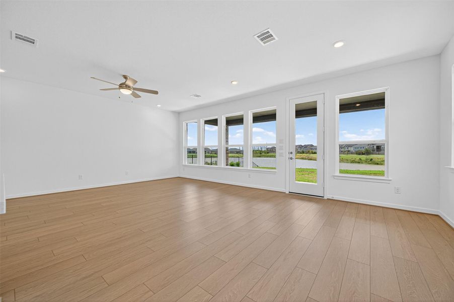 Expansive windows across the back of the home flood the living space with natural light while showcasing beautiful backyard and water views.