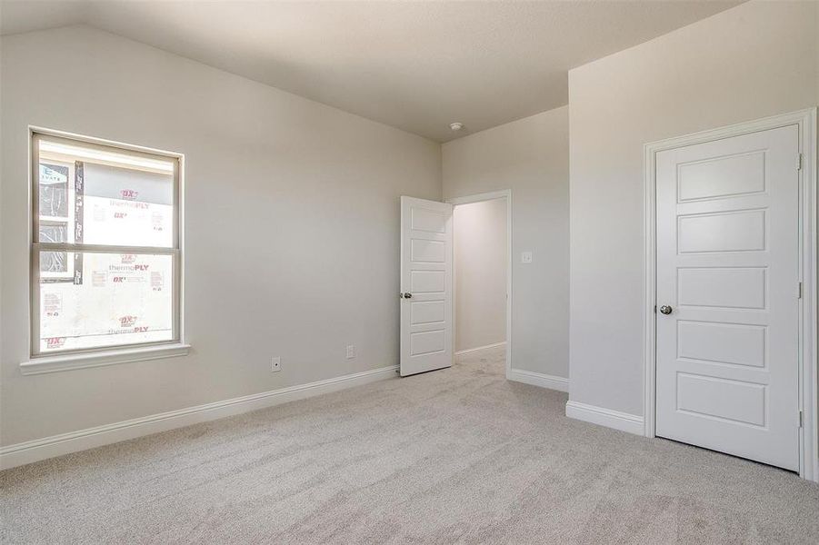 Unfurnished bedroom featuring light carpet and baseboards