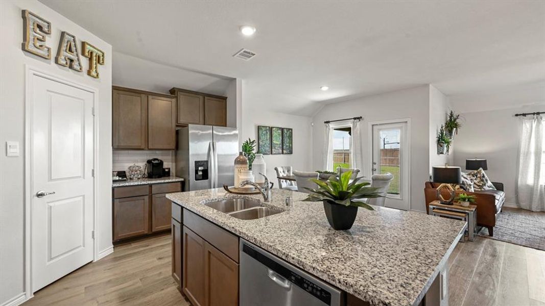 Kitchen with stainless steel appliances, open floor plan, an island with sink, light wood-style floors, and recessed lighting