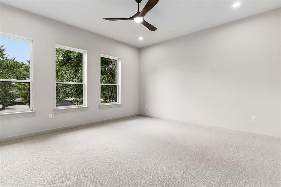 Spacious room featuring light-colored carpeting, recessed lighting, and a contemporary ceiling fan. Spacious room featuring light-colored carpeting, recessed lighting, and a contemporary ceiling fan.