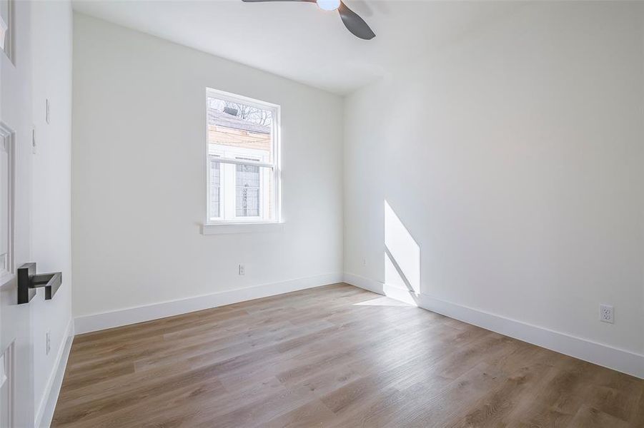 Unfurnished room with ceiling fan and light hardwood / wood-style floors