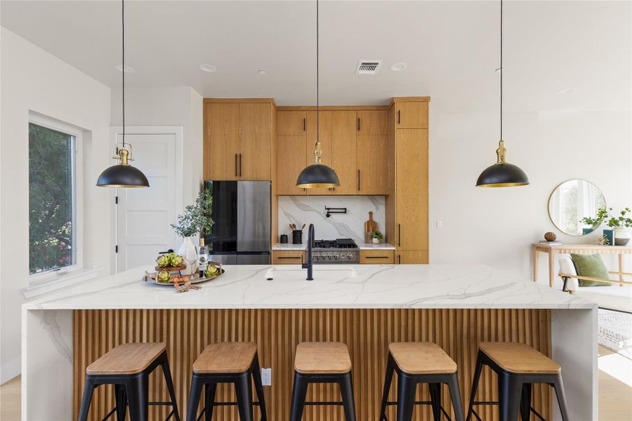 Fine cabinetry and sleek stone countertops define this elegant culinary space.