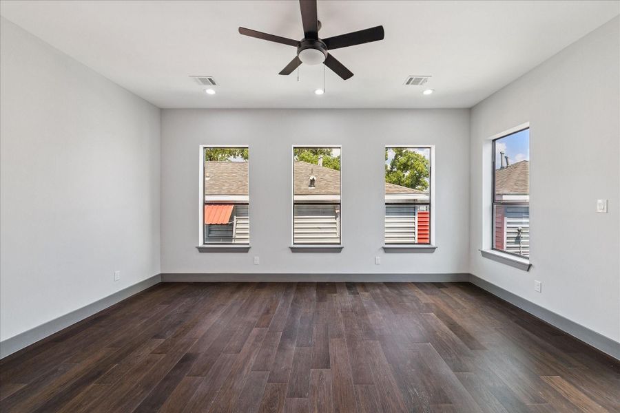 The primary suite features warm wood flooring, recessed lighting, and a ceiling fan for year-round comfort, with a sliding glass door leading to a private balcony and direct access to the en suite bath. The primary suite features warm wood flooring, recessed lighting, and a ceiling fan for year-round comfort, with a sliding glass door leading to a private balcony and direct access to the en suite bath.