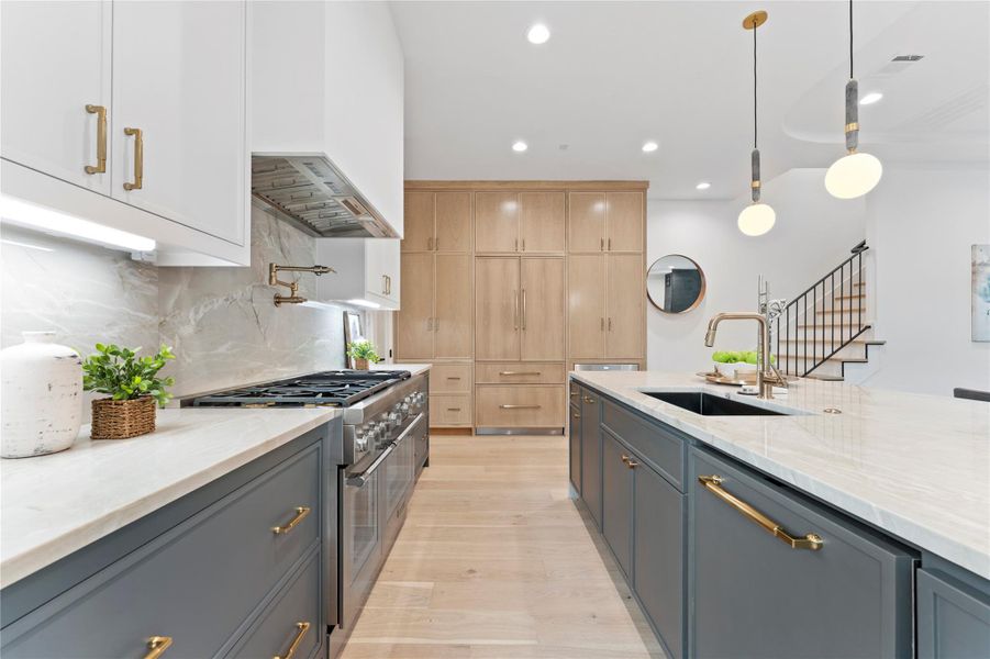 Designer kitchen with oversized island and plaster hood and premium finishes.