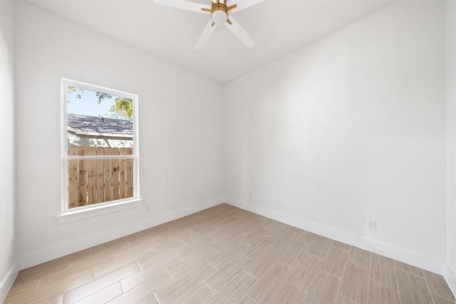 Empty room with wood tiled floors and a ceiling fan