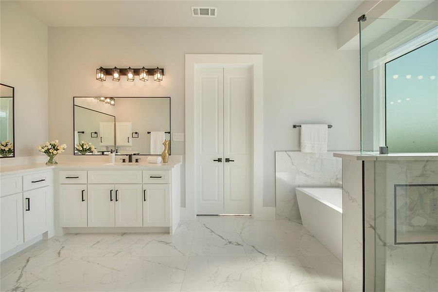 Full bath with vanity, a marble finish shower, a soaking tub, and light marble finish floors Full bath with vanity, a marble finish shower, a soaking tub, and light marble finish floors