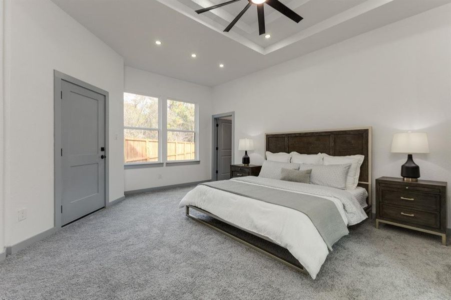 Bedroom with ceiling fan and light colored carpet