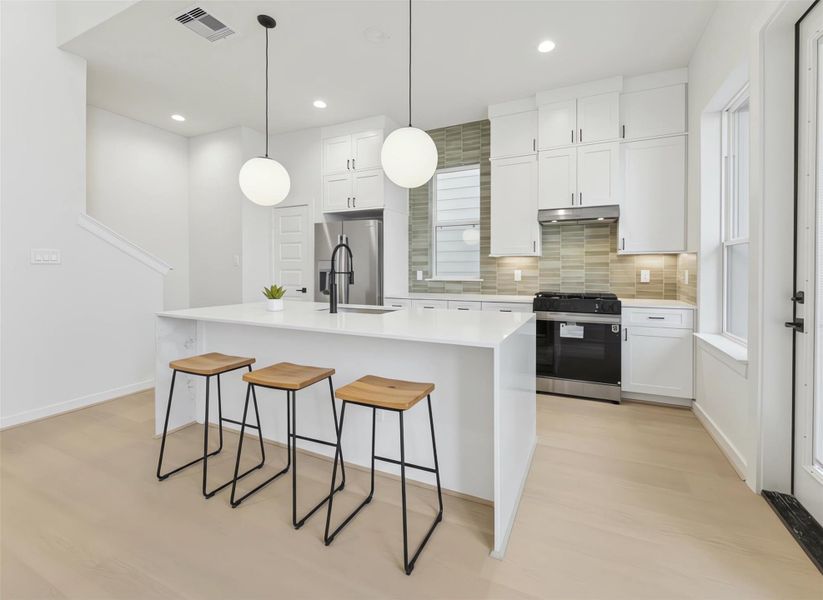 Matte black fixtures, quartz surfaces, and subtle tile accents lend a polished, modern aesthetic while maintaining a comfortable, inviting feel that connects seamlessly to the living area. *Virtually staged*