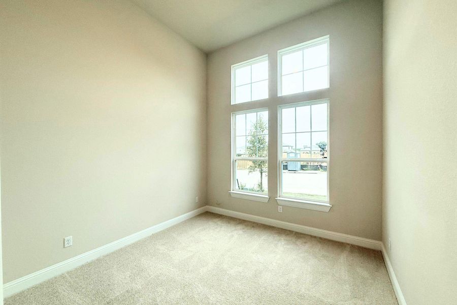 A well-lit bedroom features high ceilings and abundant natural light through multiple windows. A well-lit bedroom features high ceilings and abundant natural light through multiple windows.