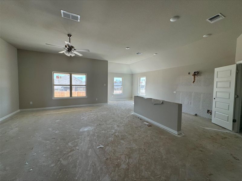 Empty room with visible vents, a ceiling fan, baseboards, and vaulted ceiling