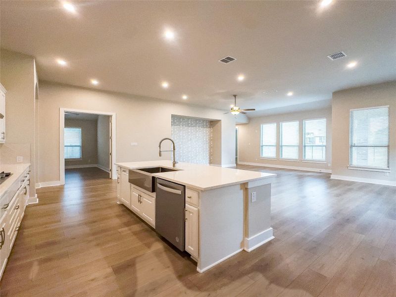Kitchen featuring white cabinets, recessed lighting, an island with sink, healthy amount of natural light, and open floor plan Kitchen featuring white cabinets, recessed lighting, an island with sink, healthy amount of natural light, and open floor plan