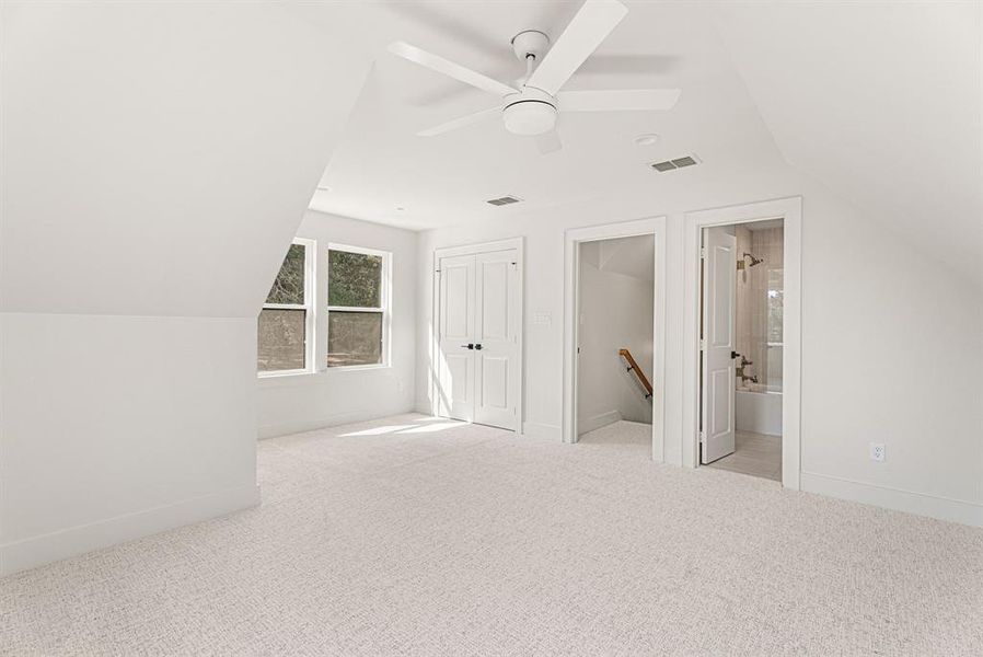 Additional living space with lofted ceiling, carpet flooring, and ceiling fan