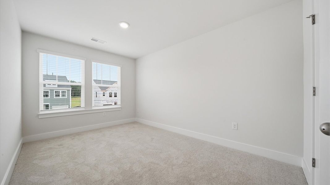 Memorable space with walk-in closet, soft carpeting, and striking natural light from large windows by DRB Homes Memorable space with walk-in closet, soft carpeting, and striking natural light from large windows by DRB Homes