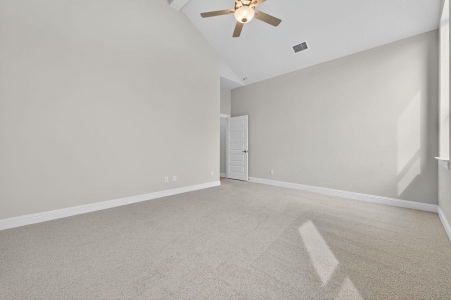 Spare room with light colored carpet, high vaulted ceiling, and a ceiling fan