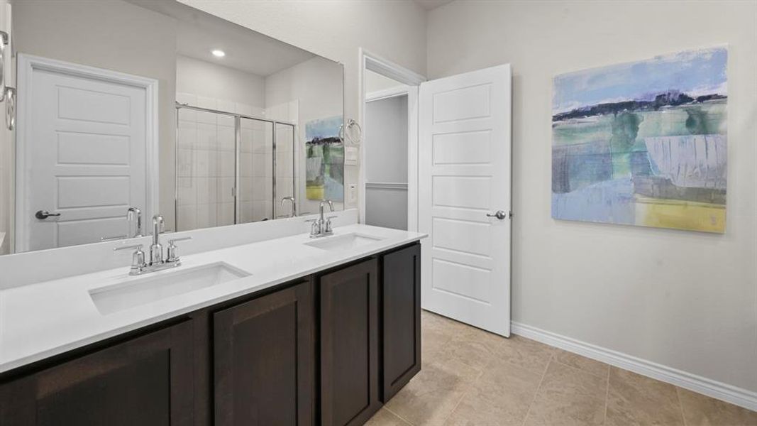 Full bathroom with double vanity and a stall shower