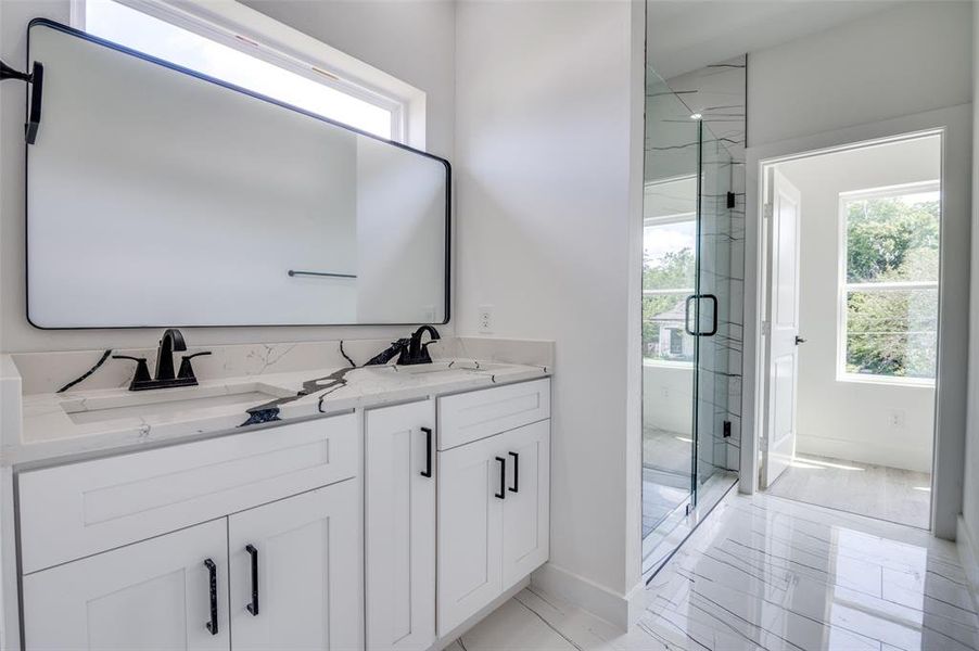 Bathroom with marble finish flooring, a marble finish shower, and double vanity Bathroom with marble finish flooring, a marble finish shower, and double vanity