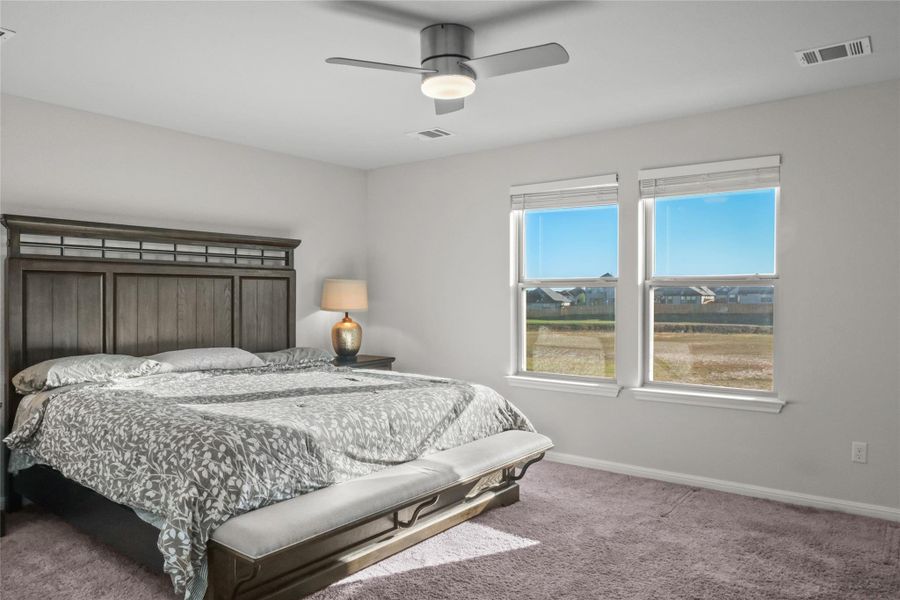 Carpeted bedroom featuring baseboards and a ceiling fan