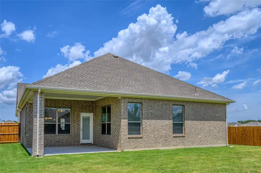 Rear view of property with a patio and a lawn