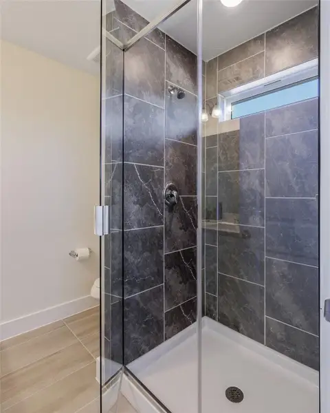 Bathroom with a stall shower and light tile patterned floors Bathroom with a stall shower and light tile patterned floors