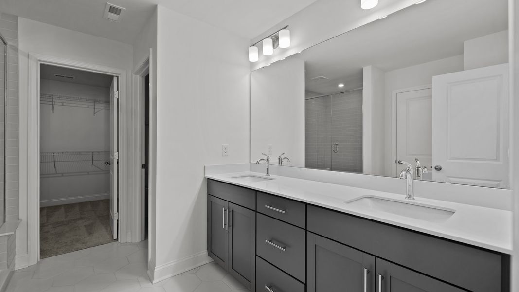 Burton Design bathroom with dual-sink vanity with easy access to walk-in closet. By DRB Homes at Lakeside Glen, York, SC.