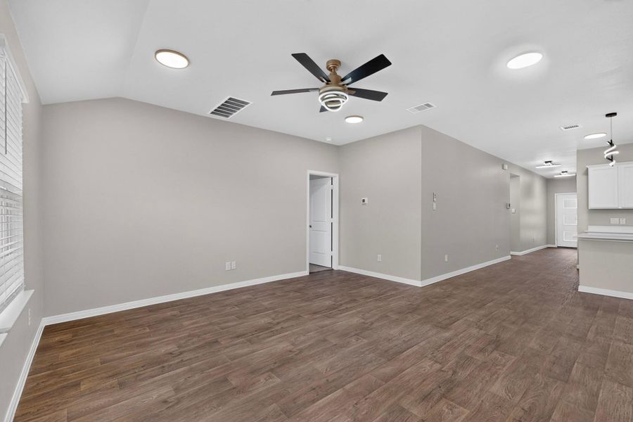 Gleaming wood-look floors anchor this airy living space with an open floor plan design.