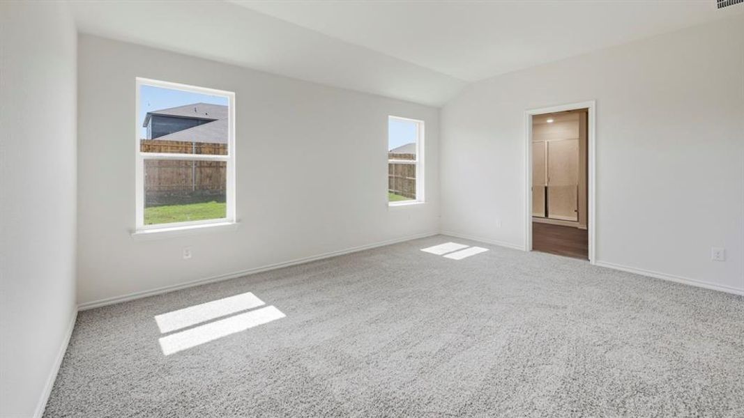 Empty room featuring lofted ceiling and carpet floors Empty room featuring lofted ceiling and carpet floors