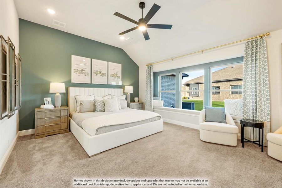 Bedroom with vaulted ceiling, ceiling fan, green accent wall, and large windows with window seat