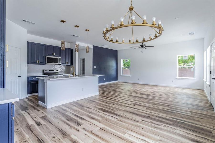Kitchen featuring appliances with stainless steel finishes, a chandelier, blue cabinets, and a ceiling fan Kitchen featuring appliances with stainless steel finishes, a chandelier, blue cabinets, and a ceiling fan