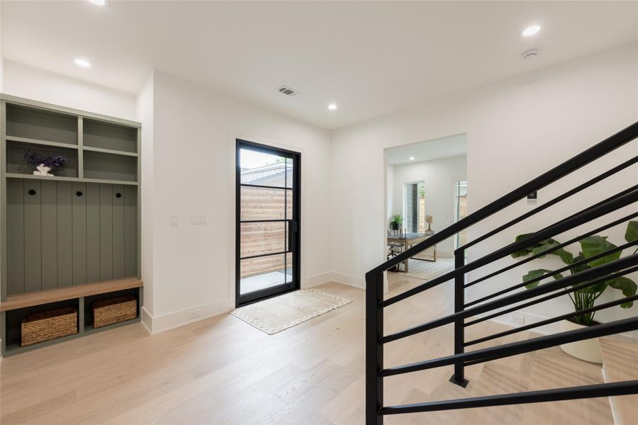 Form meeting function at the front door. Recessed lighting, a painted built-in designed to hold everything the day throws at you, and a sightline that runs clear from the entry through to the study beyond. Cedar fencing outside, crisp white walls within: the kind of quiet contrast that photographs beautifully and lives even better.