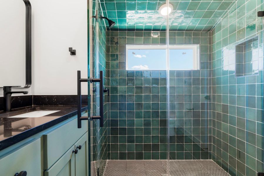 Bathroom featuring vanity and tiled shower
