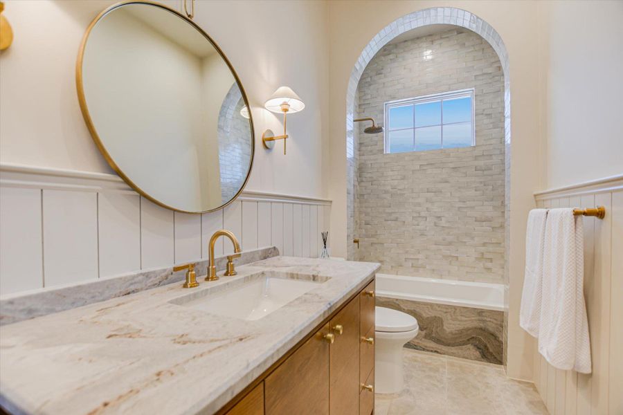 Full bath with vanity, tub / shower combination, and a wainscoted wall