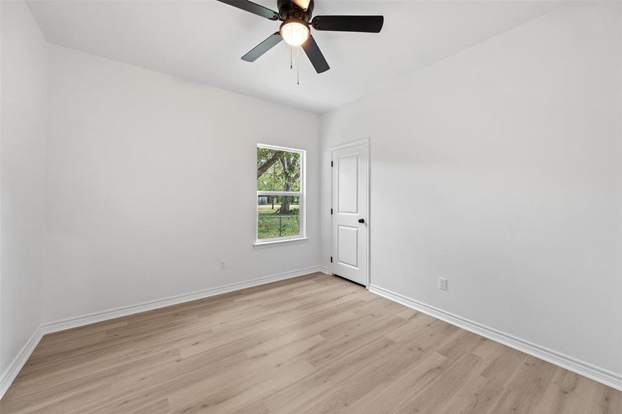 Spare room with light wood-style floors and a ceiling fan
