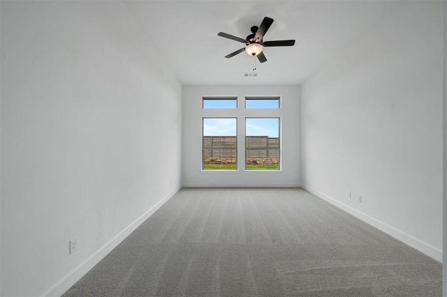 The room features a carpeted floor, white walls, and a ceiling fan with integrated lighting