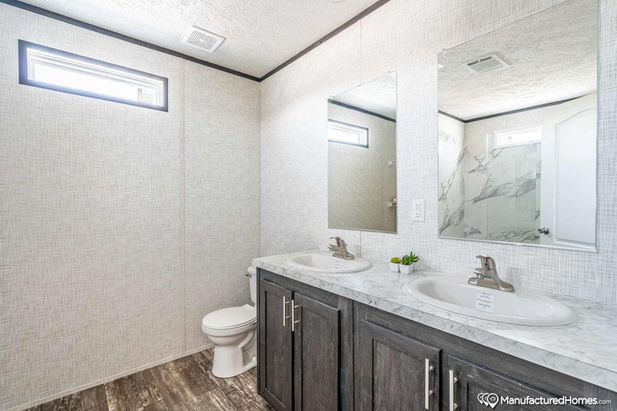A clean, modern bathroom offers a dual vanity with ample counter space and convenient mirror access.