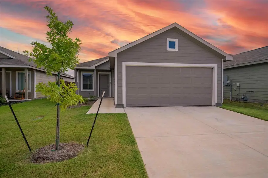 Contemporary single-story residence featuring a gray exterior siding and a matching garage door Contemporary single-story residence featuring a gray exterior siding and a matching garage door