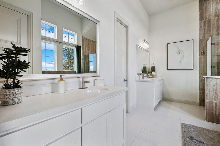 Dual vanity bathroom featuring light-toned flooring, white cabinetry, and a large wall-mounted mirror