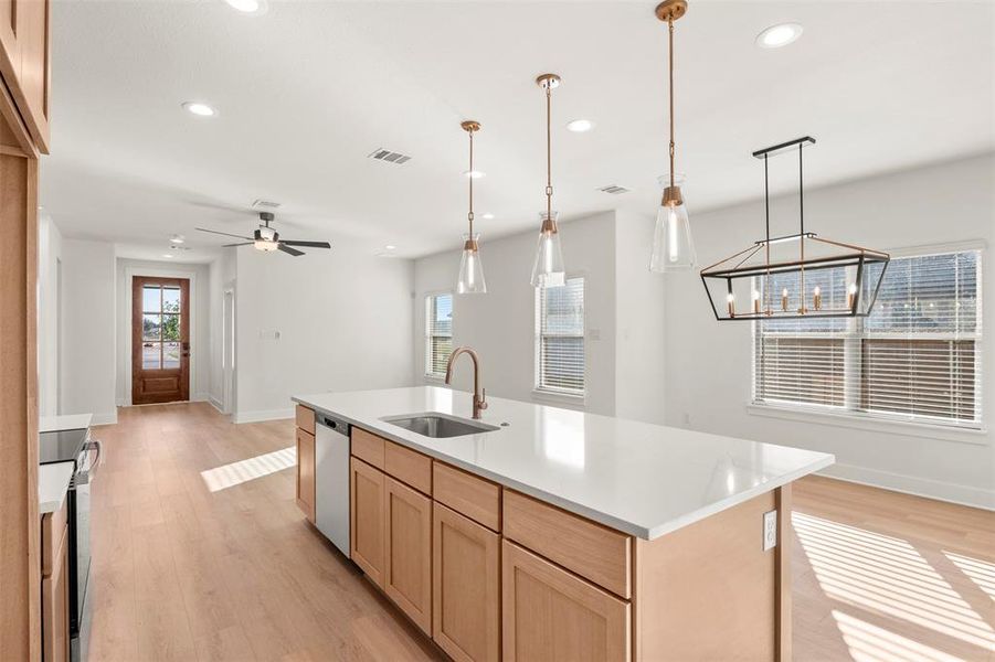 Kitchen featuring light brown cabinets, light wood-style flooring, plenty of natural light, recessed lighting, and decorative light fixtures