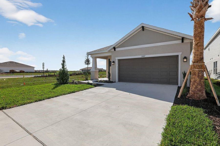Front exterior of a new home in Firethorn, Parrish, FL, highlighting curb appeal (Image 2). Front exterior of a new home in Firethorn, Parrish, FL, highlighting curb appeal (Image 2).