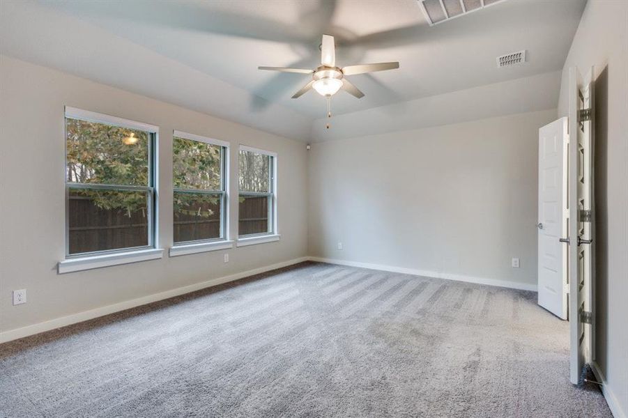 Unfurnished room featuring light carpet and a ceiling fan Unfurnished room featuring light carpet and a ceiling fan